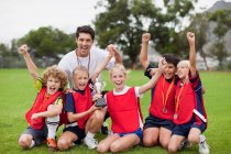 Children cheering with coach — Stock Photo