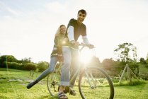 Retrato de pareja joven en bicicleta - foto de stock