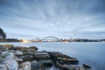 Langzeitbelichtung von felsigem Ufer und entfernter Brücke — Stockfoto
