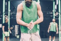 Milieu de la section masculine cross-trainer craie mains dans la salle de gym — Photo de stock