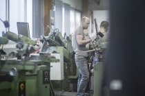 Hommes adultes caucasiens travaillant dans l'atelier de meulage — Photo de stock