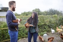 Junges Paar auf Hühnerfarm hält Hühner — Stockfoto