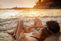 Couple posé sur le sable à la plage, mise au point sélective — Photo de stock