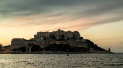 Vue imprenable sur la mer et Calvi sur le promontoire au crépuscule, Corse, France — Photo de stock