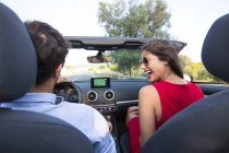 Young couple laughing whilst driving on rural road in convertible, Majorca, Spain — Stock Photo