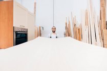 Menuisier avec grande feuille de bois en atelier — Photo de stock
