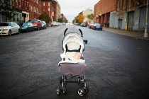 Baby boy asleep in push chair in middle of street — Stock Photo