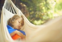 Mignon garçon inclinable dans jardin hamac endormi — Photo de stock