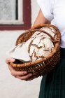Mulher segurando cesta de pão sourdough — Fotografia de Stock