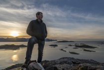 Человек поднимается на вершину на острове Квалоя осенью, Арктическая Норвегия — стоковое фото