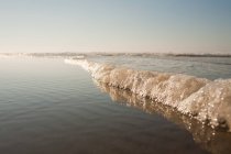 Морской прибой на краю воды — стоковое фото