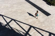 Hochwinkelige Ansicht einer Frau in Anzug, die durch Plaza, Rom, Latium, Italien läuft — Stockfoto
