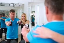 Trainer stellt Männerform im Fitnessstudio ein — Stockfoto