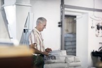 Male miller stock taking sacks of flour at wheat mill — Stock Photo