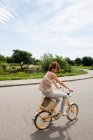 Donna in bicicletta su strada rurale — Foto stock