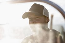 Портрет людини в бейсбольному капелюсі на човні, дивлячись далеко — стокове фото