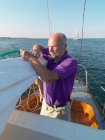 Mann passt Takelage auf Segelboot an — Stockfoto