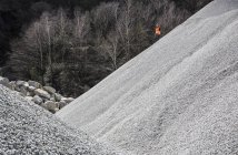 Operaio cava su cumulo di ghiaia in cava — Foto stock