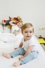 Porträt eines kleinen Mädchens mit Schwester im Bett — Stockfoto