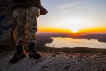 Турист насолоджується видом на озеро на заході сонця, обрізане зображення — стокове фото