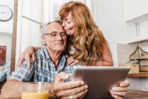 Casal mais velho usando computador tablet — Fotografia de Stock