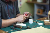 Trabalhador masculino na oficina de couro, fazendo pulseira de relógio de couro, seção meio, close-up — Fotografia de Stock