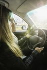 Sobre a visão do ombro da mulher dirigindo carro — Fotografia de Stock