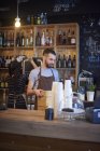 Baristas working behind counter in coffee shop — Stock Photo