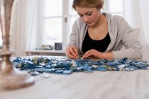 Teenage girl working on jigsaw puzzles — Stock Photo