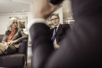 Empresária e empresários em reunião de poltrona — Fotografia de Stock
