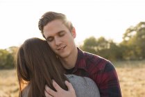 Young couple in rural setting, embracing — Stock Photo