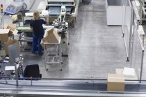 Mulher madura trabalhando na fábrica de embalagens de papel — Fotografia de Stock