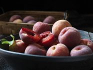 Albaricoques rojos orgánicos frescos con hoja en tazón - foto de stock