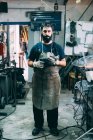 Porträt eines männlichen Metallarbeiters in Schürze, Schmiedewerkstatt — Stockfoto