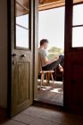 Homme lisant sur le porche — Photo de stock