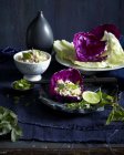 Chicken larb salad served in red cabbage leaf with lime half — Stock Photo