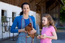 Contadina con gallina, figlia con uova — Foto stock