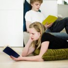 Children reading in living room — Stock Photo