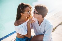 Young woman with finger on boyfriend's lips at poolside, Koh Samui, Thailand — Stock Photo