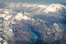 Mountain range with snowcapped peaks and lake, aerial view — Stock Photo