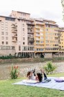 Lesbian couple lying on front on blanket next to Arno river, Florence, Tuscany, Italy — Stock Photo