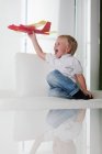 Молодий хлопчик грає з іграшковим літаком — стокове фото