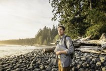 Hombre mirando desde la playa en el Parque Provincial Juan de Fuca, Isla Vancouver, Columbia Británica, Canadá - foto de stock