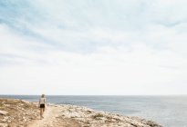 Vista posteriore della donna che cammina sulla scogliera, Minorca, Spagna — Foto stock