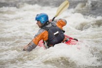 Rear view of male kayaker paddling River Dee rapids — Stock Photo