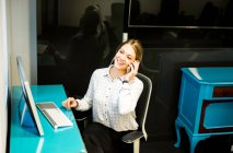 Empresária falando no smartphone na mesa de escritório — Fotografia de Stock