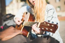 Женщина на улице играет на гитаре — стоковое фото