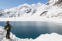 Mid adult man, fishing, Morasco lake, Morasco, Val Formazza, Piemonte, Italie — Photo de stock