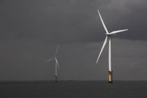 Wind turbines in ocean with cloudy sky — Stock Photo