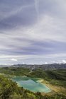 Vista aérea sobre Kalterer Veja o lago e colinas verdes sob céu nublado — Fotografia de Stock